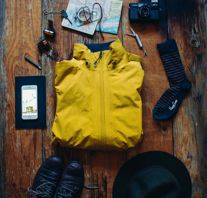 Exploration essentials: boots, map, camera, jacket for your next adventure.