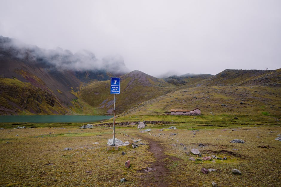 Scenic mountain view in Pajchanta, Qosqo, Peru with foggy peaks and a serene trekking path.